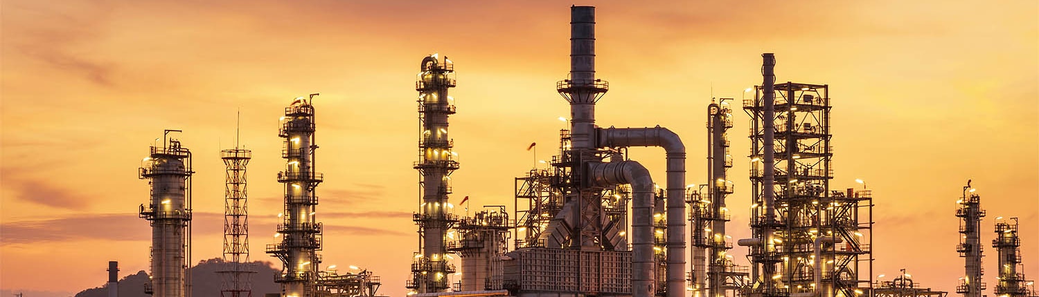 Industrieanlage bei Sonnenuntergang mit Zone 1 EX Leuchte für sichere Beleuchtung in explosionsgefährdeten Bereichen.